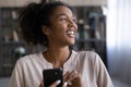 Close up smiling dreamy African American woman holding smartphone Royalty Free Stock Photo