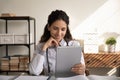 Close up smiling female doctor using tablet, watching webinar