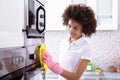 Janitor Cleaning Oven In The Kitchen Royalty Free Stock Photo