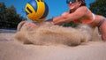 CLOSE UP: Smiling female volleyball player dives and strikes ball with her hands Royalty Free Stock Photo