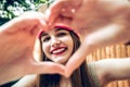 Close up of smiling girl with healthy skin showing love sign. Royalty Free Stock Photo