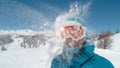 CLOSE UP: Smiling girl wearing ski goggles gets hit in the head by a snowball.