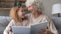 Close up smiling mature grandmother and little granddaughter reading book Royalty Free Stock Photo