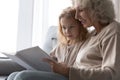 Close up smiling mature grandmother reading book to granddaughter Royalty Free Stock Photo