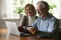 Close up smiling mature man and woman paying online together Royalty Free Stock Photo