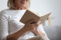 Close up smiling mature woman reading interesting book Royalty Free Stock Photo