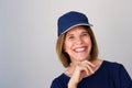 Close up smiling older woman with hat against gray wall Royalty Free Stock Photo