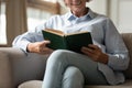 Happy mature woman relax on couch at home reading book Royalty Free Stock Photo