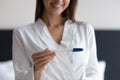 Close up smiling woman holding pregnancy test, satisfied by result Royalty Free Stock Photo