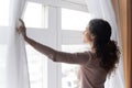 Close up smiling woman opening curtains in morning, enjoying sunlight Royalty Free Stock Photo