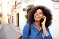 Close up smiling woman talking on mobile phone walking on street Royalty Free Stock Photo