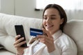 Close up smiling woman using phone, paying by credit card Royalty Free Stock Photo