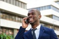 Close up smiling young african american businessman talking with cellphone in city Royalty Free Stock Photo