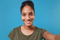 Close up of smiling young african american woman girl in casual t-shirt posing isolated on blue background in studio Royalty Free Stock Photo