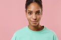 Close up of smiling young african american woman girl in green sweatshirt posing isolated on pastel pink wall background Royalty Free Stock Photo