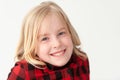 Close up of a smiling young blonde preteen girl on a white studio background
