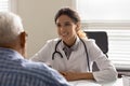 Smiling female doctor consult elderly male patient in clinic Royalty Free Stock Photo