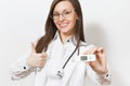 Close up smiling young doctor woman in medical gown with stethoscope glasses showing thumbs up, clinical electronic Royalty Free Stock Photo