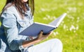 Close up of smiling young girl with book in park Royalty Free Stock Photo