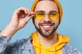 Close up of smiling young hipster guy in fashion jeans denim clothes posing isolated on pastel blue background studio Royalty Free Stock Photo