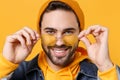 Close up of smiling young hipster guy in fashion jeans denim clothes posing isolated on yellow orange wall background Royalty Free Stock Photo