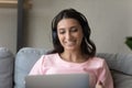 Happy ethnic woman in earphones talk on laptop Royalty Free Stock Photo
