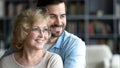 Close up smiling young man and mature mother dreaming together Royalty Free Stock Photo