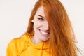 Close up of smiling young redhead woman girl in casual yellow hoodie posing isolated on white background studio portrait Royalty Free Stock Photo