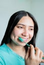 Close up of smiling young woman with braces brushing her teeth in the bathroom. Oral Hygiene routine