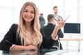 Smiling young woman sitting at a Desk in the office Royalty Free Stock Photo