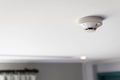 Close up of a smoke detector attached on the ceiling of the hotel room