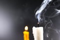 Smoke on white candle soft lens yellow candle in the dark background Royalty Free Stock Photo