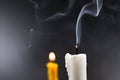 Smoke on white candle soft lens yellow candle in the dark background Royalty Free Stock Photo