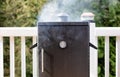 Close up of a smoker with fresh smoke coming out of barbeque coo