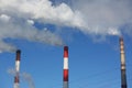 Smoking pipes of heating plant supplying heat to city, power station with three smoke stacks Royalty Free Stock Photo