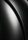 A close-up of a smooth, curved black metallic surface with brushed texture. The lightin Royalty Free Stock Photo