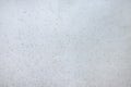 Close-up of smooth light grey surface with dark dots all over the picture. Plain minimal textured background with copy space. Royalty Free Stock Photo