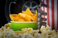 Close-up of snacks at the cinema bar, with videotape and a bucket of nachos