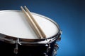 Close-up of a snare drum with two drumsticks and blue wall Royalty Free Stock Photo