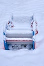 Close up of a snow covered boat shaped seesaw teeter totter in a children play park during the cold winter season