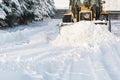 Close - up of snowplow plowing road during storm. Winter snow removal tractor.