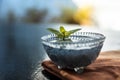 Close up of soaked sabja seeds or falooda seeds or sweet basil seeds in a glass bowl on brown colored napkin on wooden surface wit