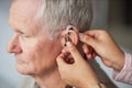 Deaf senior man wearing hearing aid Royalty Free Stock Photo