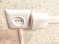 Close-up of a socket and switch on a decorative wall. European Wall Socket and Switch on a Patterned Background