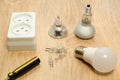 Close - up of sockets and white light bulbs on a light, wooden table. Royalty Free Stock Photo