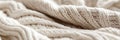 Close-up of soft beige knitted fabric with intricate cable pattern design Royalty Free Stock Photo