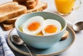 A close-up of a soft boiled egg in a cup with a slice of toast on the side Royalty Free Stock Photo