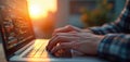 Close-up of software developer hands coding on laptop keyboard. Sunset light and bokeh background. Coder works with program