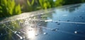 Close-up of solar panel surface with water droplets. Sunlight reflects on clean energy source, green plants in background. Eco Royalty Free Stock Photo