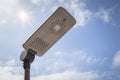 Solar street lamp on metal pole with blue sky and sunlight in background. Royalty Free Stock Photo